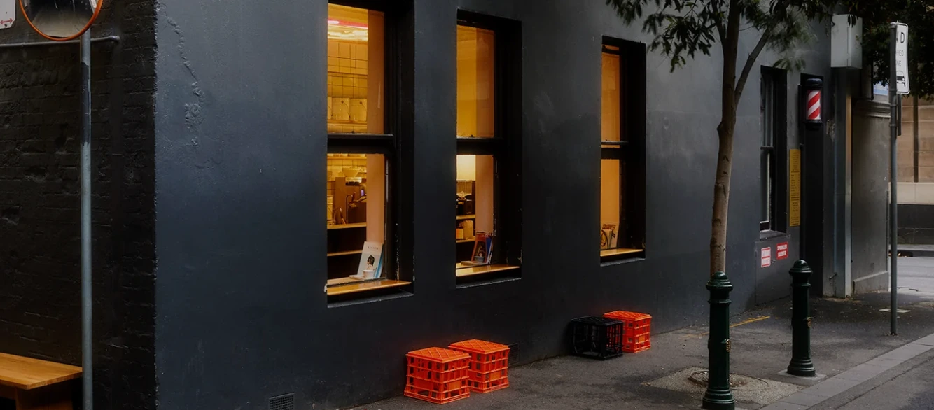 The entrance to Patricia Coffee Brewers on a Melbourne CBD laneway, with its café sign and coffee-bar window.